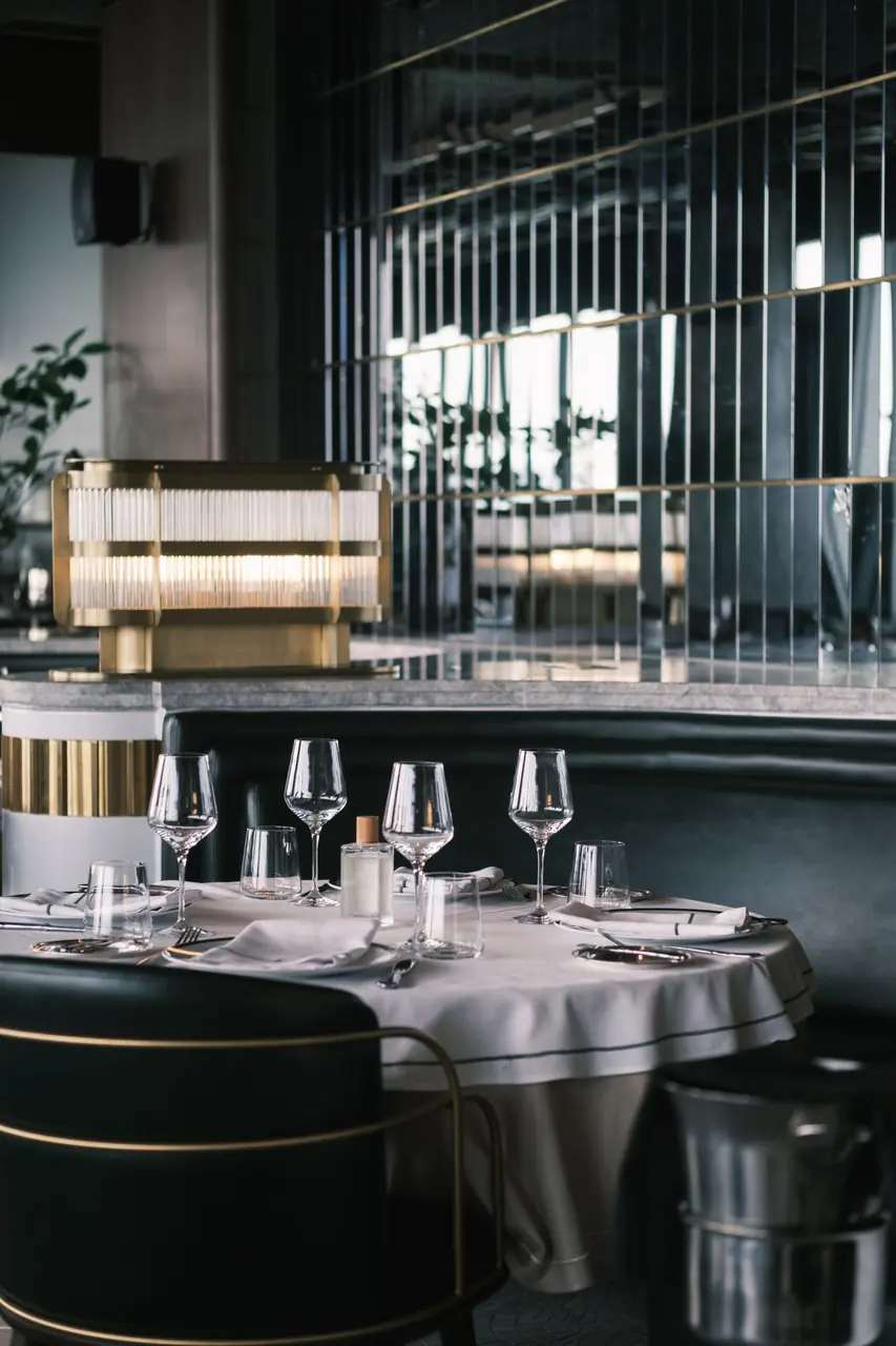 Modern restaurant dining table with refined water glassware and tailored linens