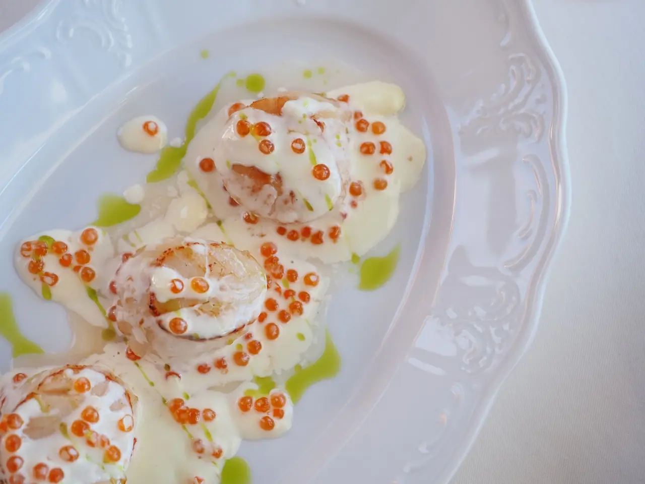 Seared scallop preparation with velvety sauce and micro chives