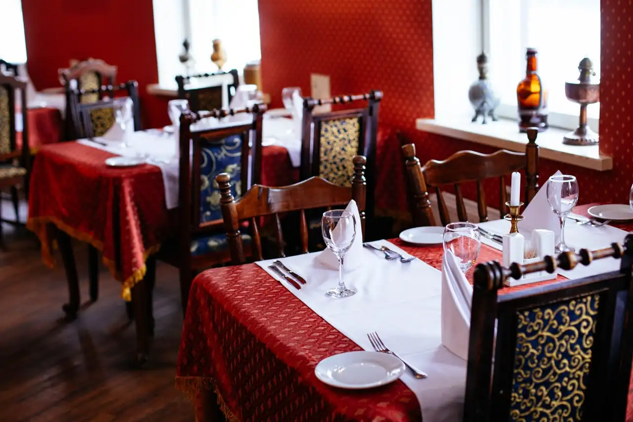 Lavishly set private dining table with polished silverware and warm ambient lighting