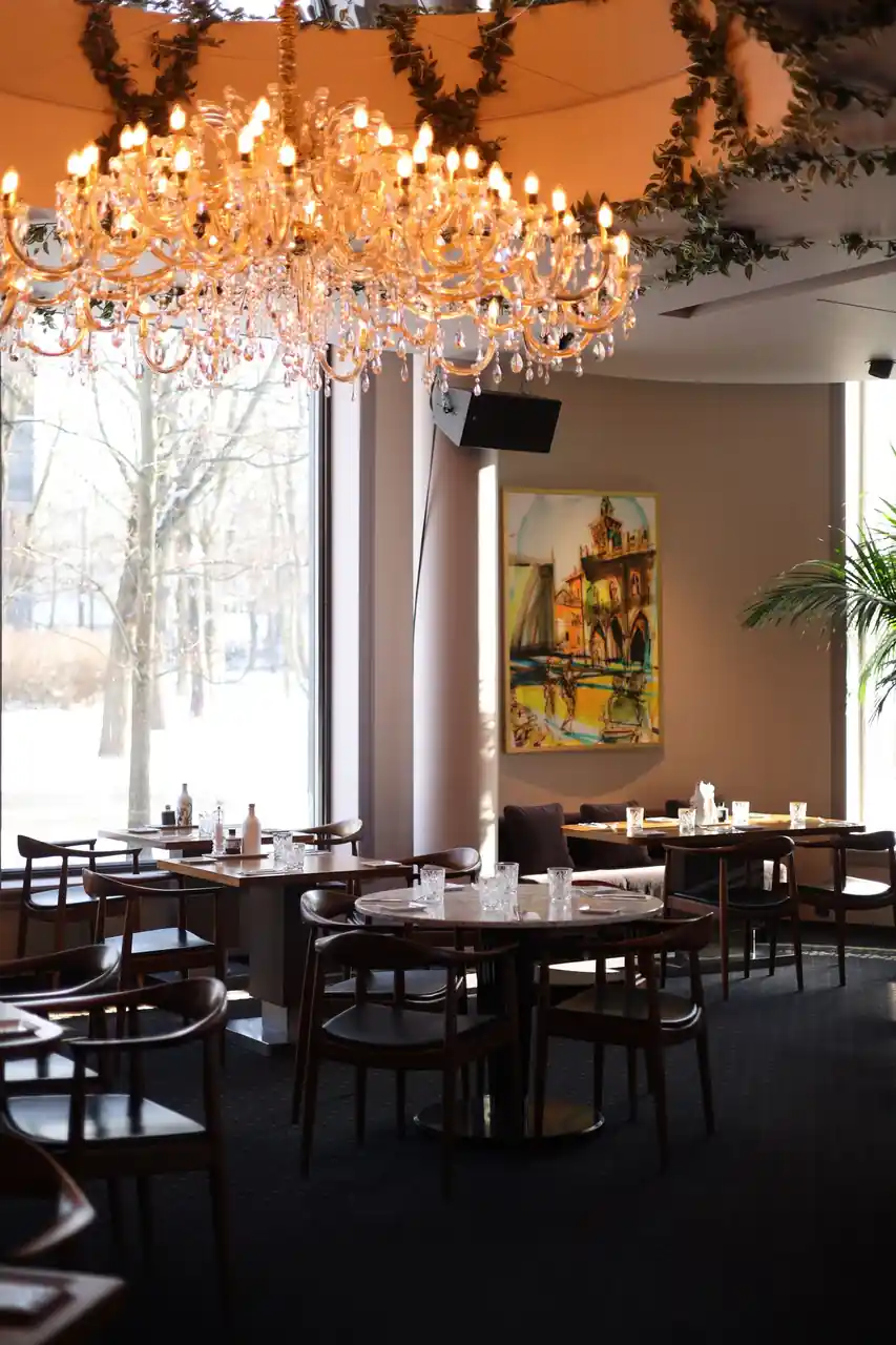 Sophisticated dining room interior with crystal lighting, warm wood panels, and finely appointed tables