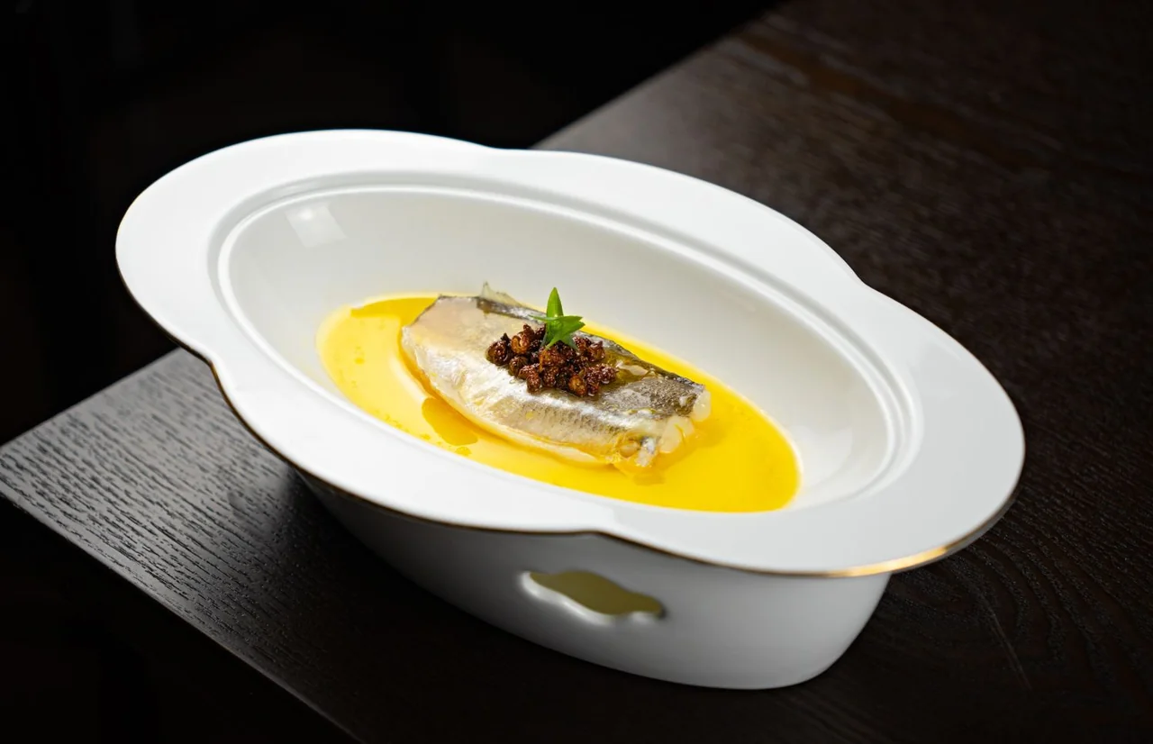 Artfully plated contemporary Canadian fish dish with delicate emulsion, herb oil, and garden microgreens