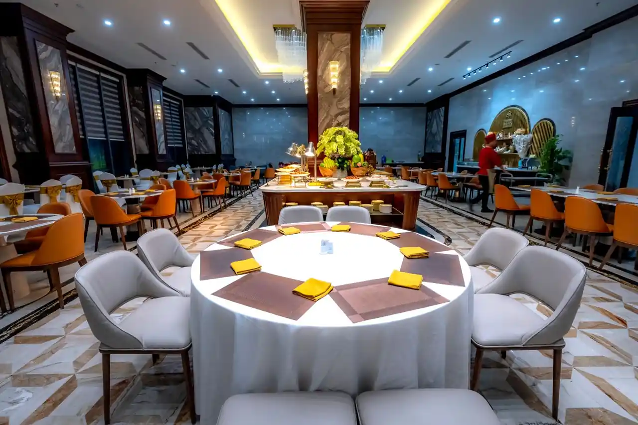 Spacious dining hall area with elegant wood finishes, warm illumination, and intimate booths