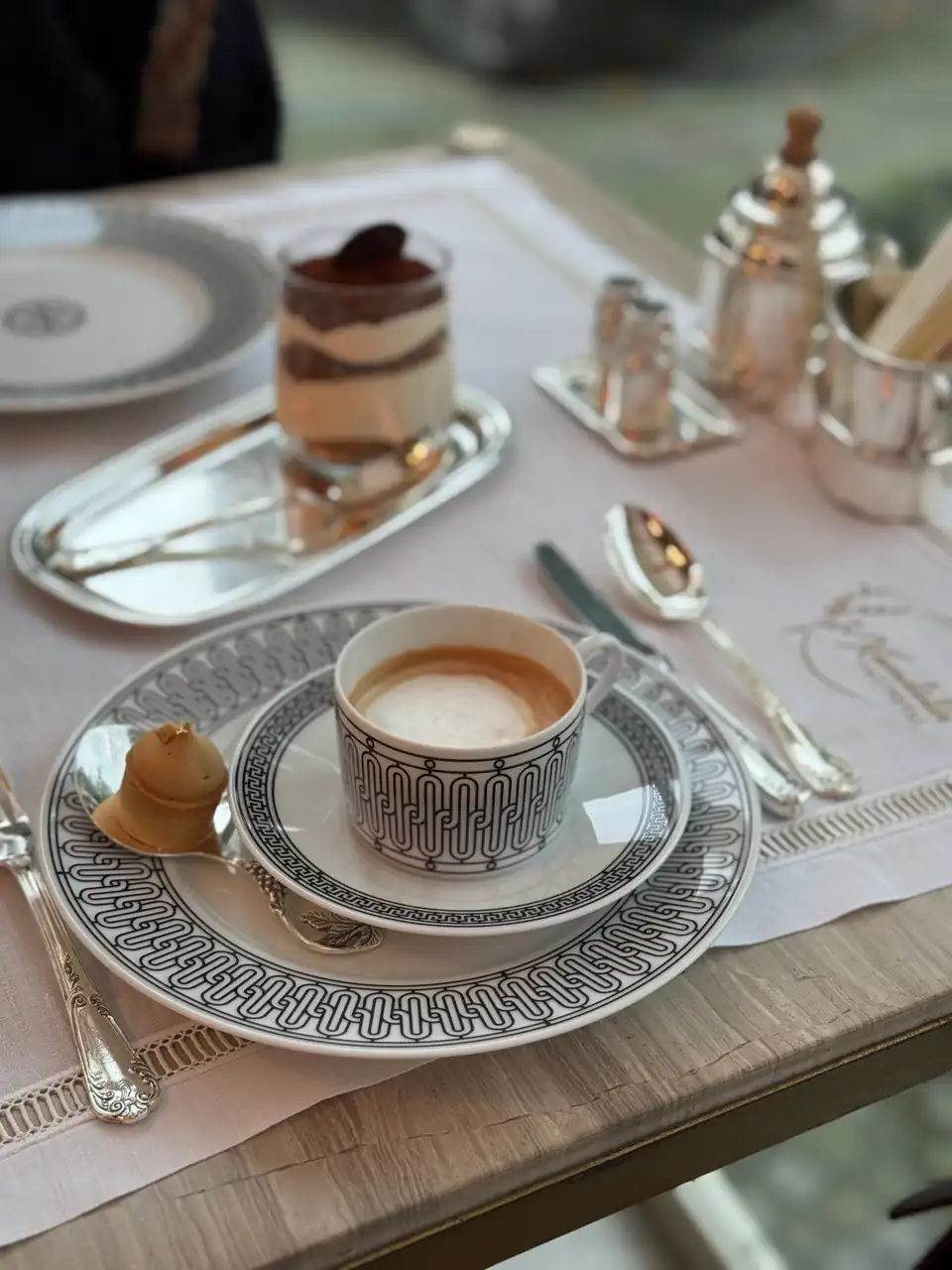 Luxurious coffee and dessert service on polished silver tableware in fine dining room